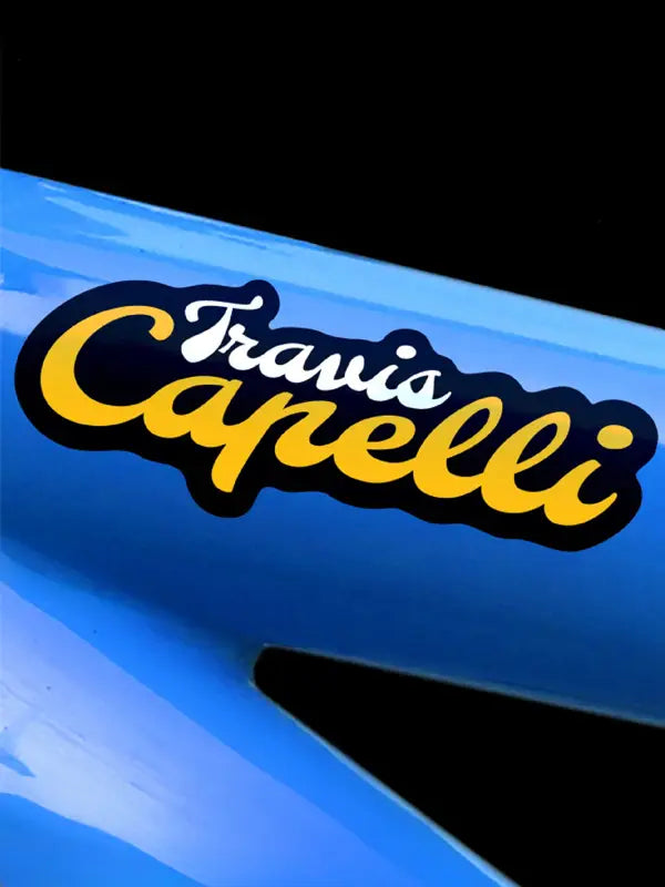 Custom bike name sticker in black and golden yellow on glossy blue bike frame.