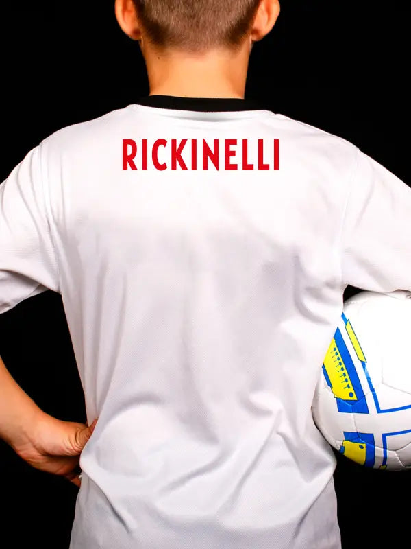 Boy in white kit with red RICKINELLI name applied using football name and number iron on transfers.
