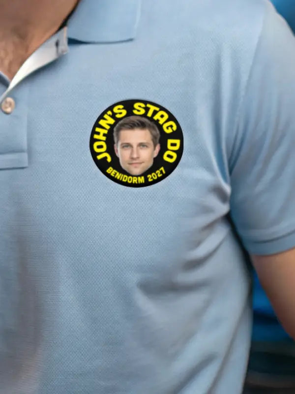 Blue polo shirt with circular stag party sticker featuring face and yellow Benidorm text.