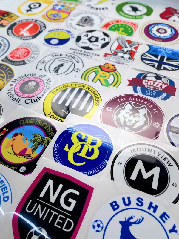 Assorted sports sponsor iron on transfers laid out for product visual reference