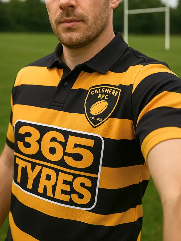 Man wearing black and gold rugby shirt with iron on sponsors transfer for rugby shirt featuring bold 365 Tyres logo on chest.