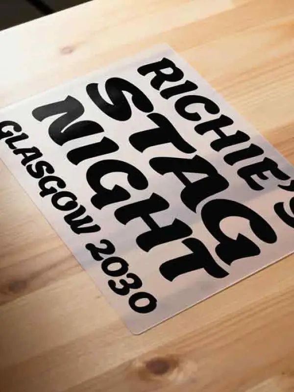 Sticker with text 'Ritchie Stag Night Glasgow 2030' on a wooden surface
