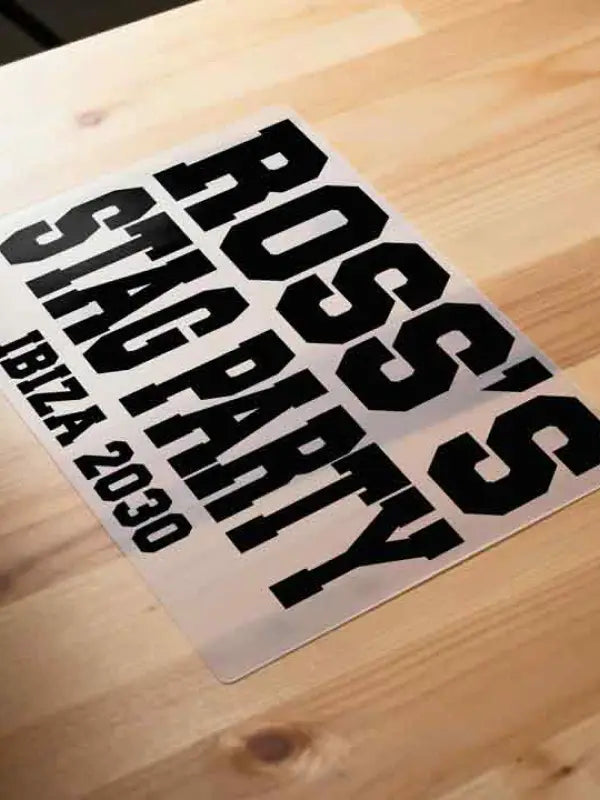 Iron On transfer with 'ROSS'S STAGPARTY IBIZA 2030' text on a wooden surface