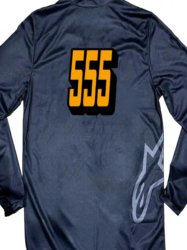 Close-up of a black motocross jersey featuring number only in bright orange iron on transfers with black shadows.