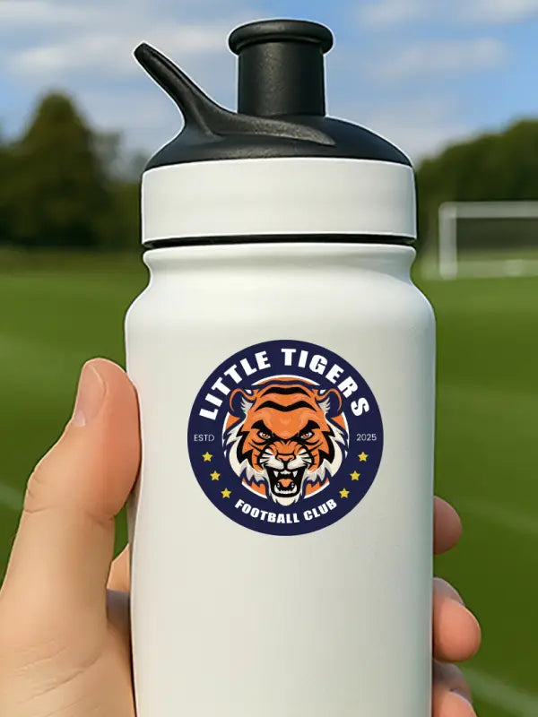 White bottle on pitch with Little Tigers personalised bottle sticker club badge, perfect for football team branding.
